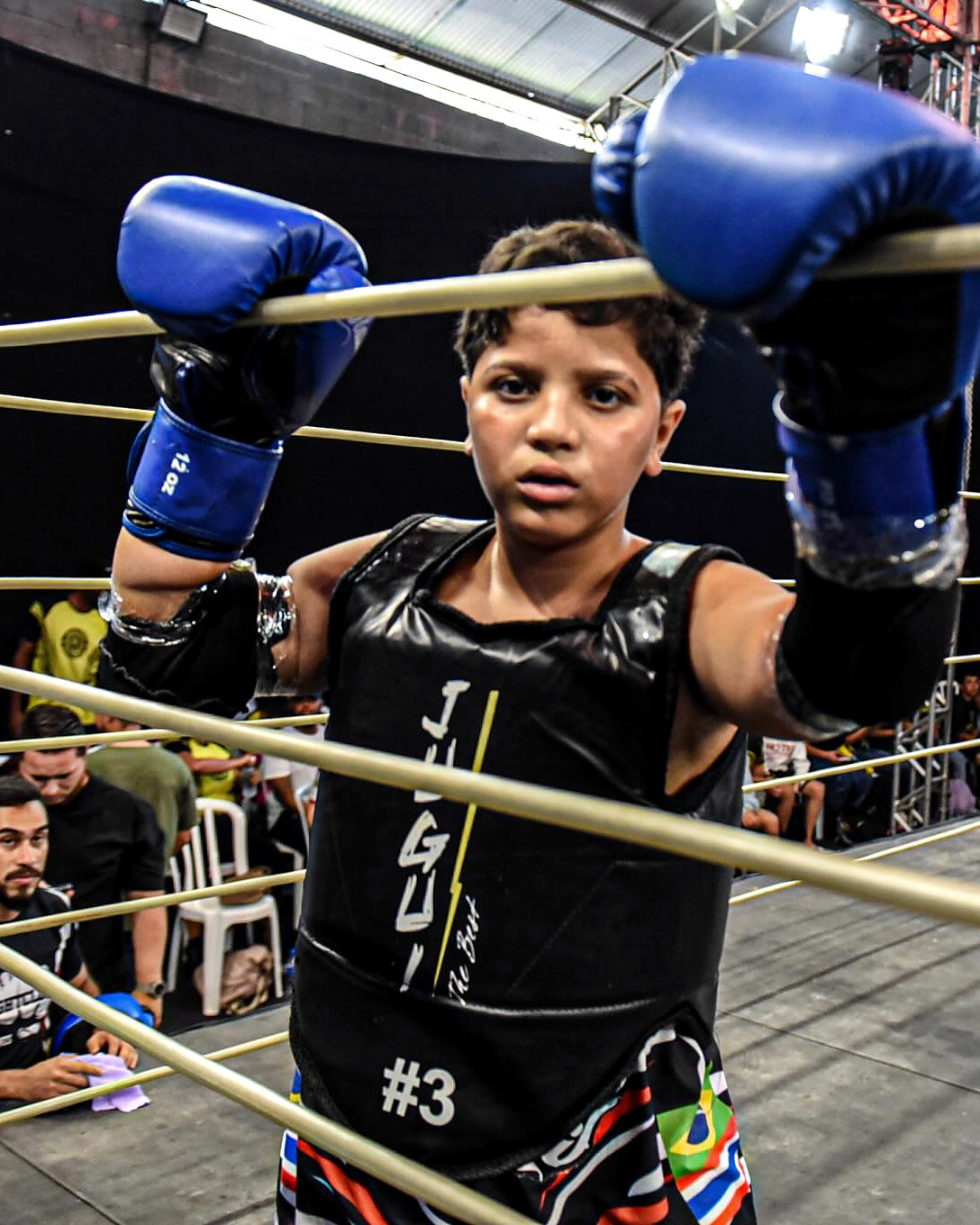 Atleta kids do Clã no córner, com luvas azuis